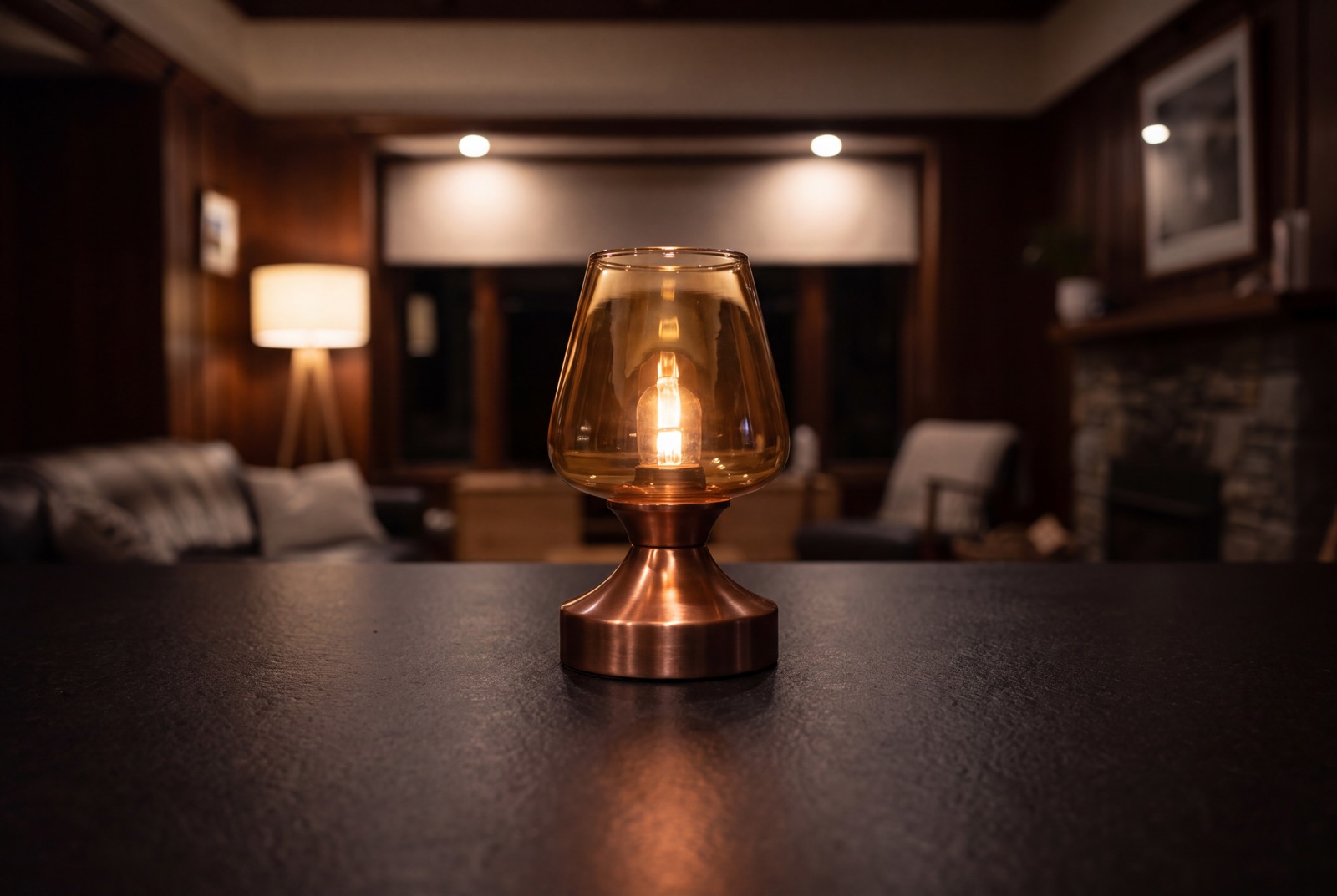 A copper table lamp glowing on a dark table, an illustrative still, not a job photo